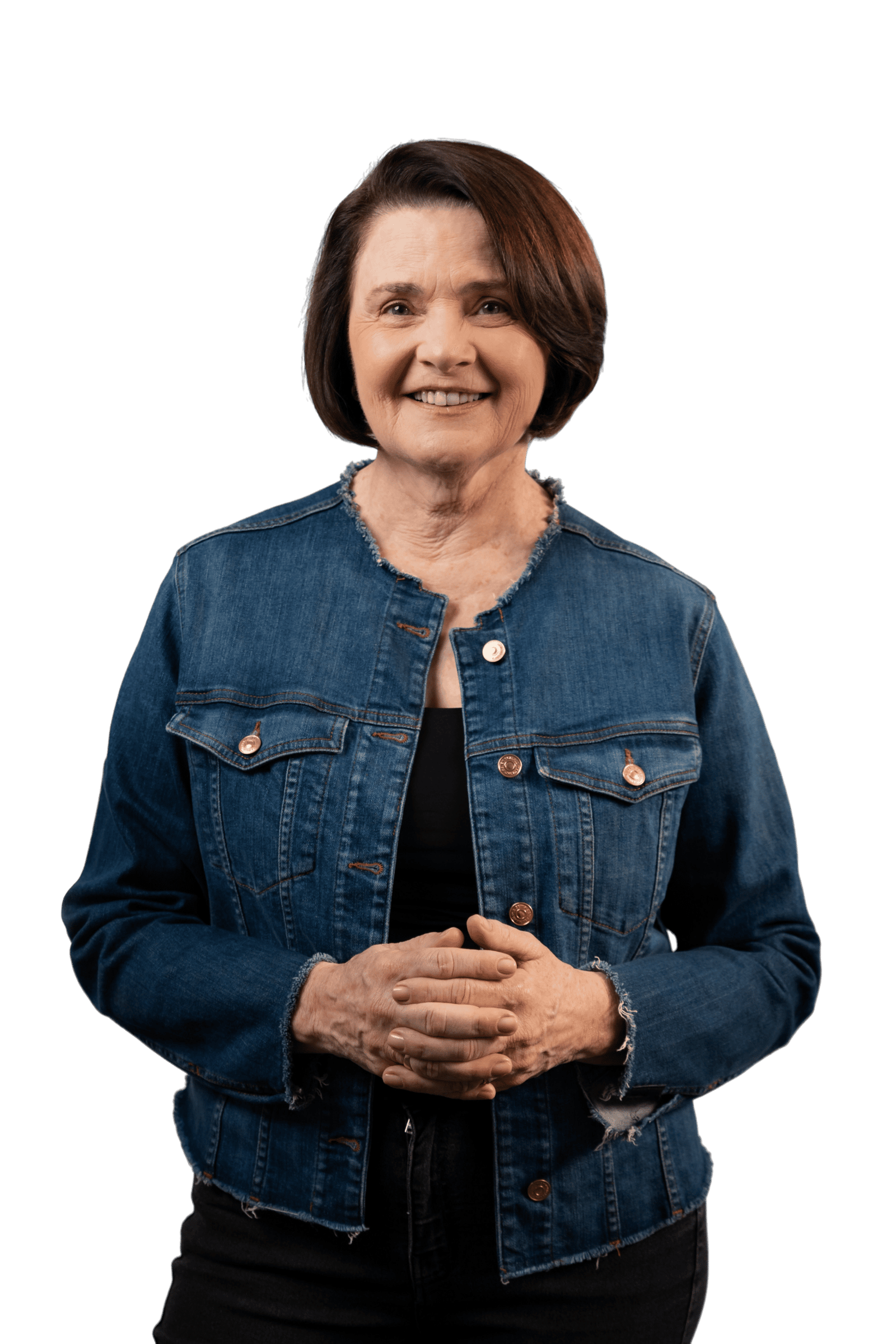 Nancy Thame de jaqueta azul, em pé, com as mãos à frente, olhando para a câmera.