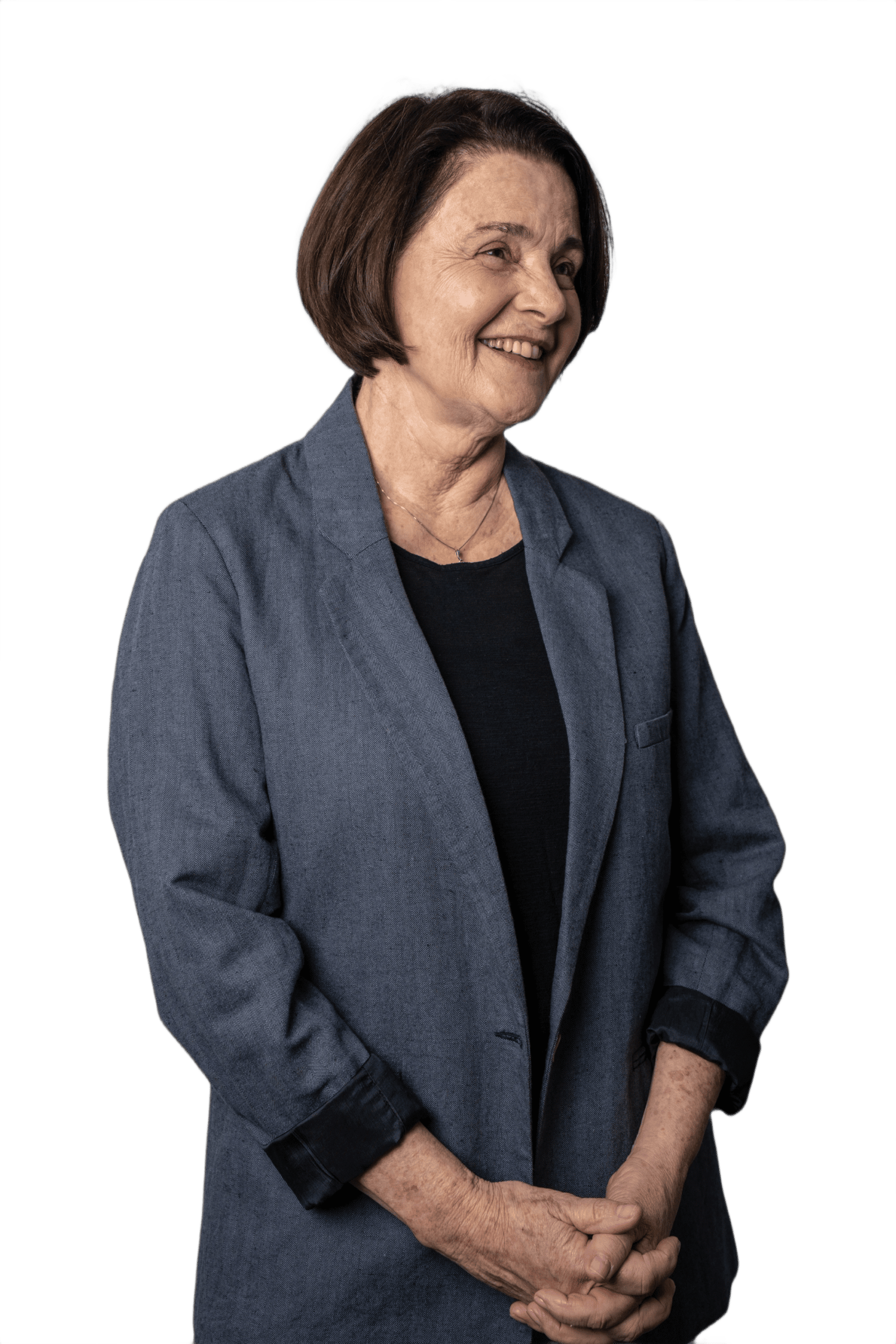 Nancy Thame de blazer azul, em pé, com as mãos à frente, olhando para a câmera.